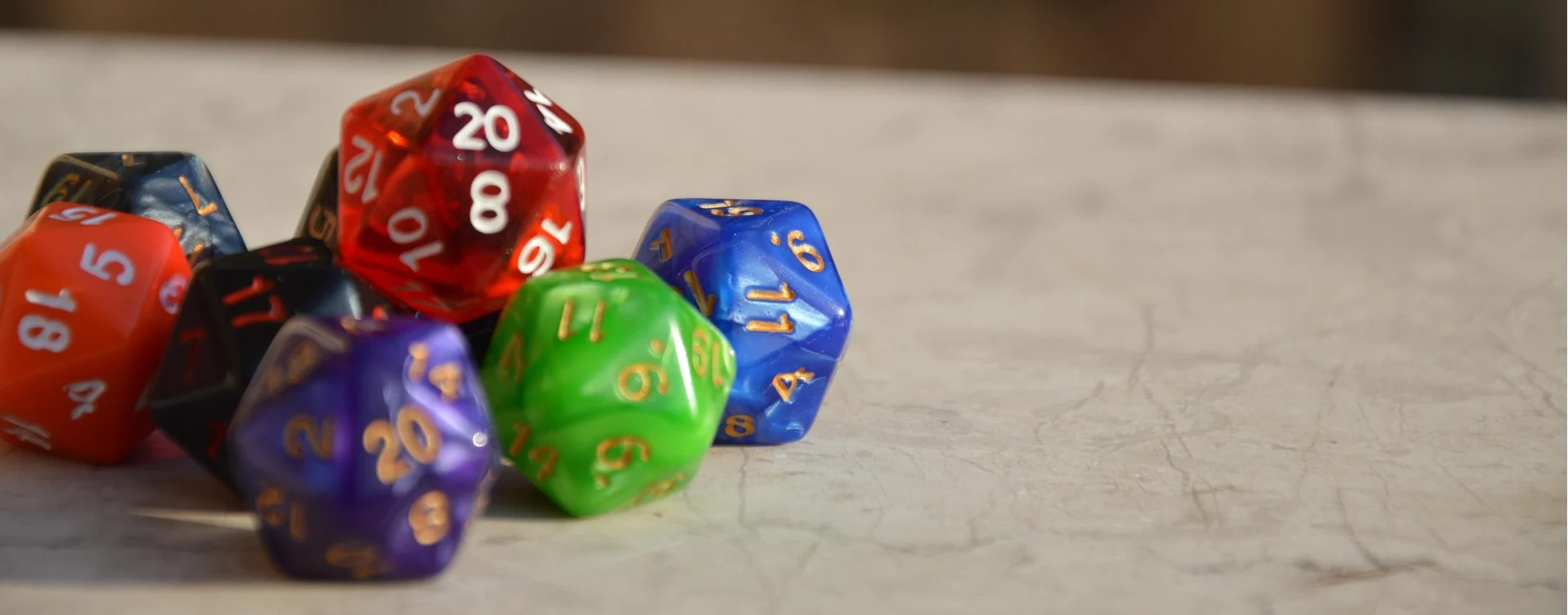 A variety of colourful dice, to illustrate an article on storytelling (including through TTRPGs)