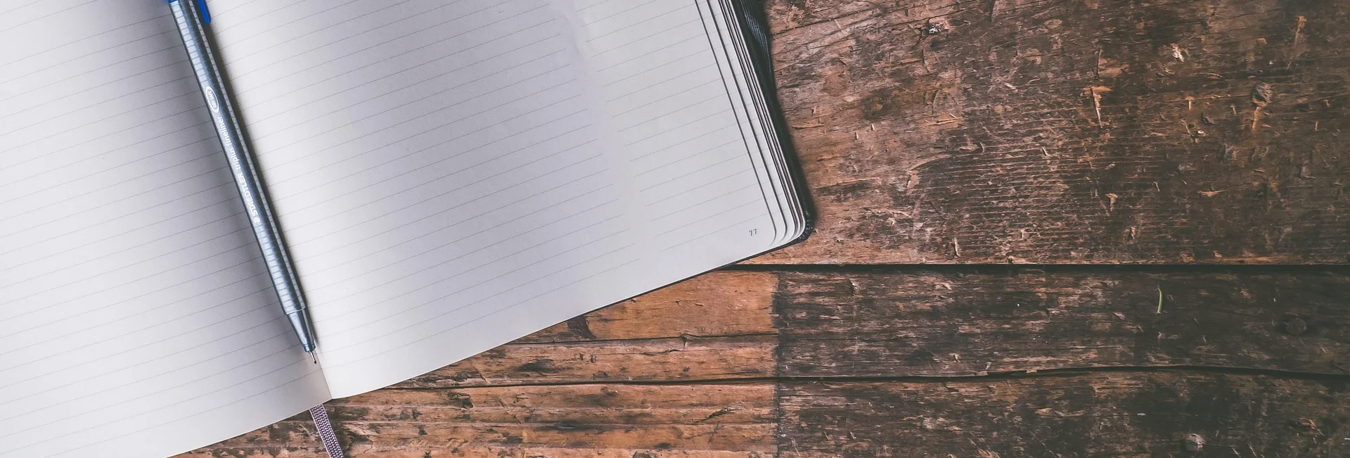 A blank, open notebook on a wooden table, to illustrate an article on the value of creative projects
